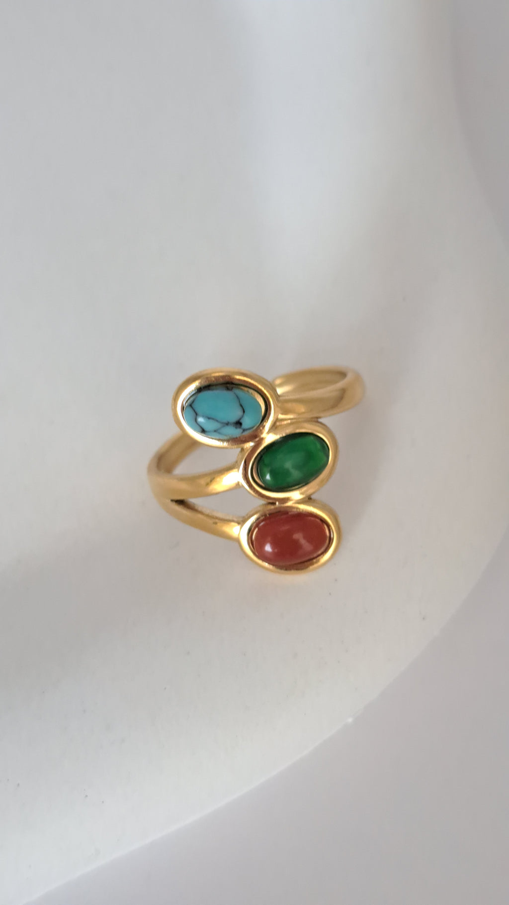 Anillo de acero dorado con tres piedras naturales
